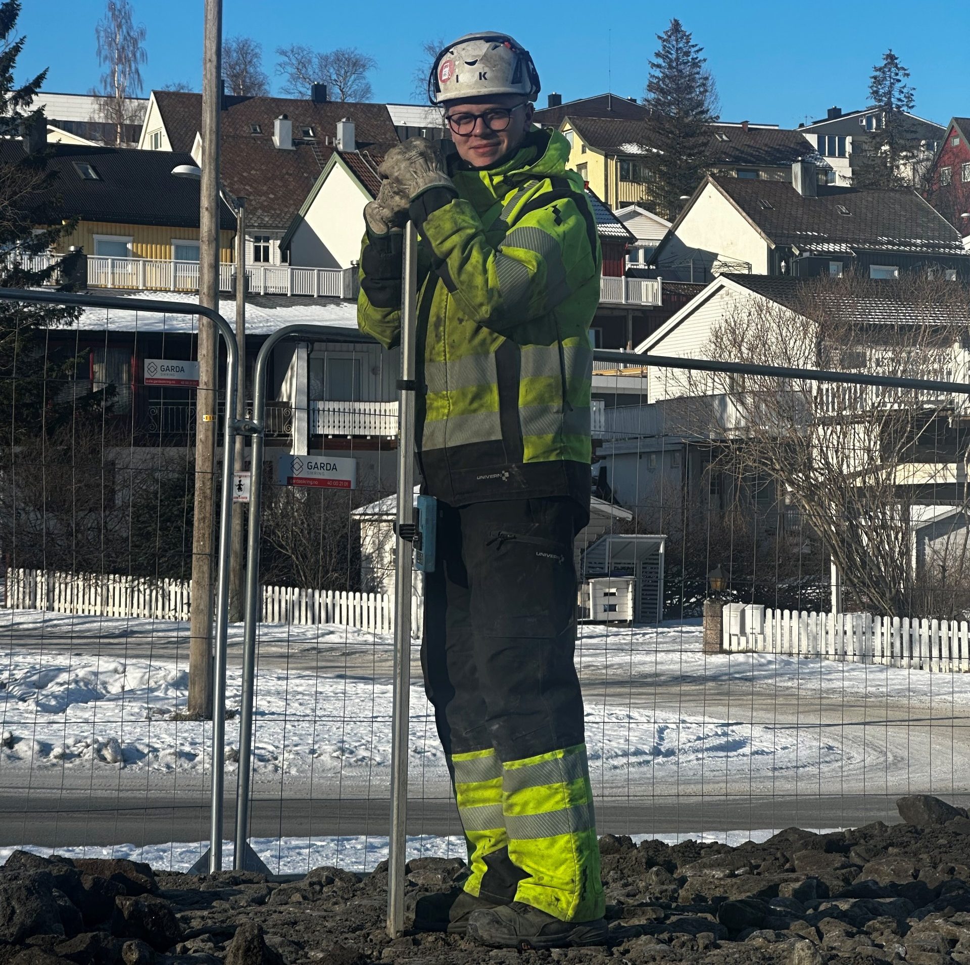 a man in a reflective jacket holding a shovel