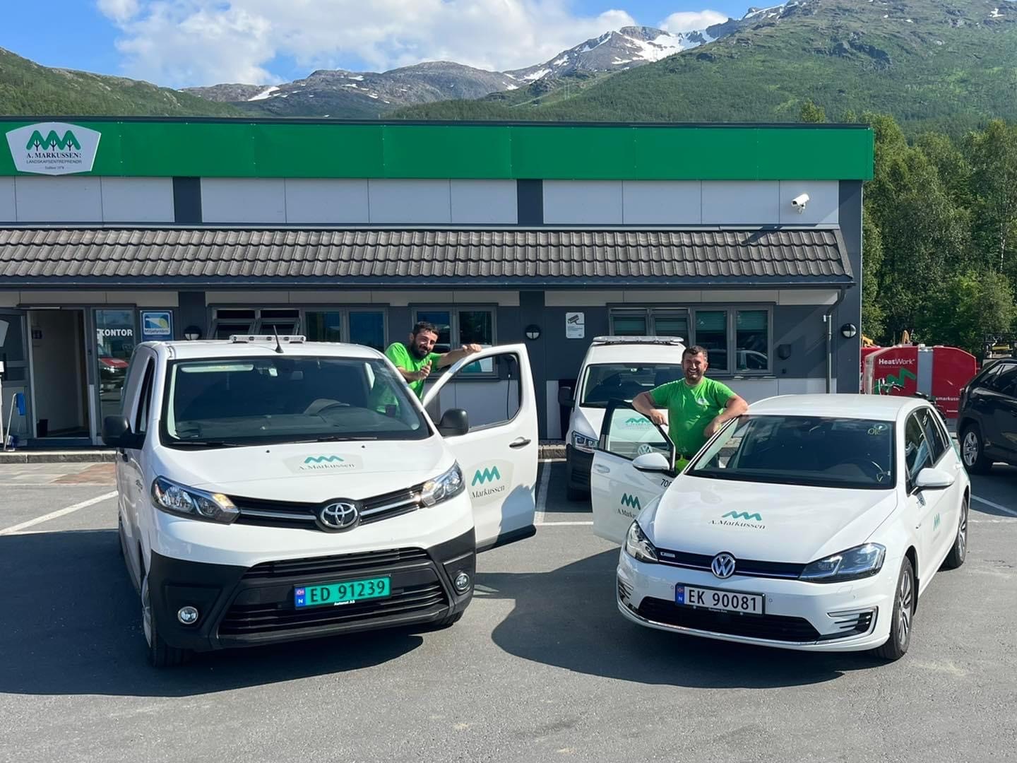 a group of men standing next to cars in front of a building